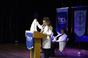A photo Ashley Larsen, MPA, PA-C, Associate Program Director of Clinical Education, MSPA program, giving the keynote address during the Spring 2023 MSPA White Coat Ceremony.