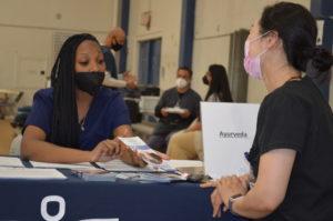 A photo of a patient receiving a healthcare consultation at an SCU Health Tent Event