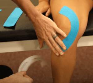 Dr. Fanning applies kinesio tape onto a SCU Health patient